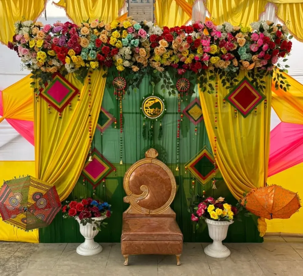 Haldi mehndi decoration with yellow drapes, colourful flowers, umbrellas and bride seating in Patna